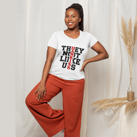 Woman wearing a white t-shirt with text and red pants standing against a white curtain.