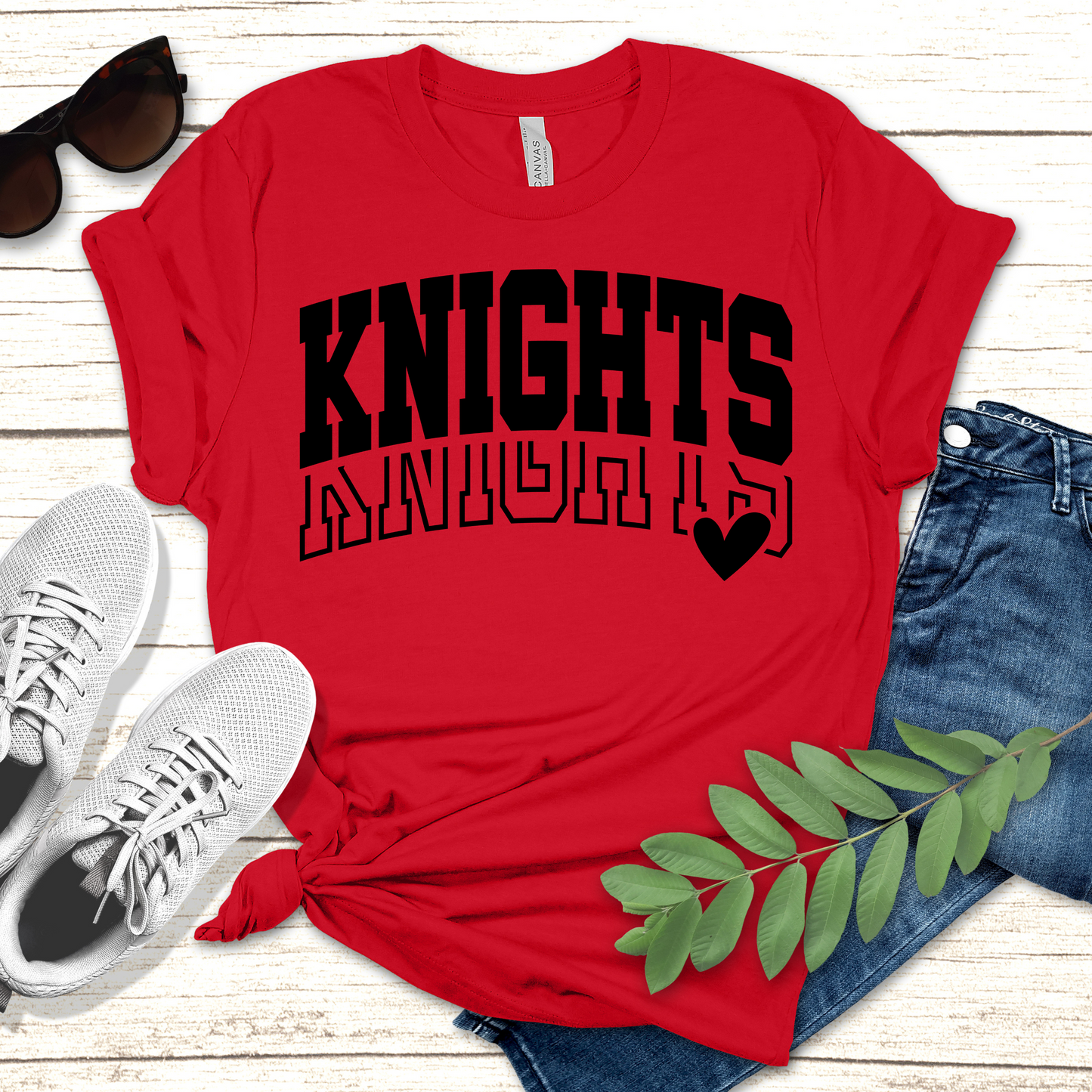 Red t-shirt with 'KNIGHTS' print on a wooden surface with shoes and jeans. Knights School Spirit Shirt - Knights Varsity - Knights Spirit Tee