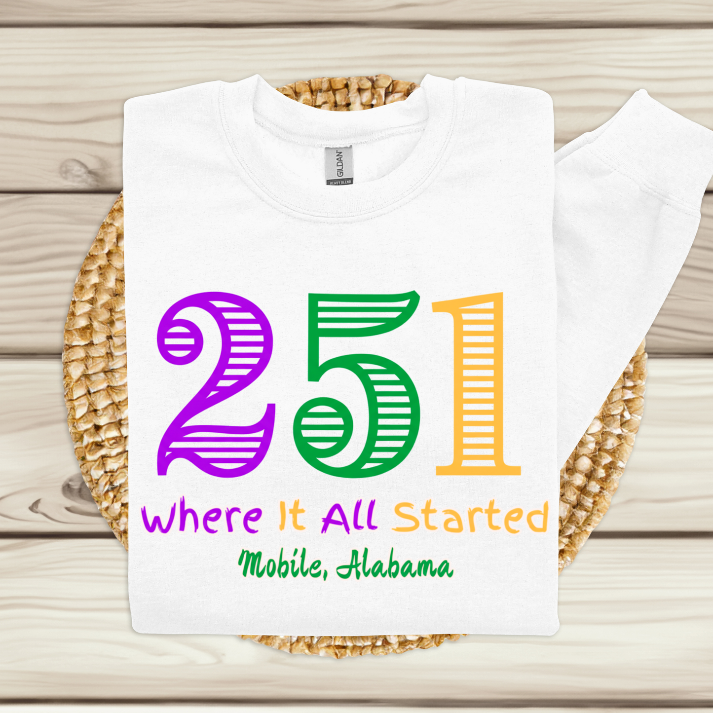 White t-shirt with colorful text on a woven mat