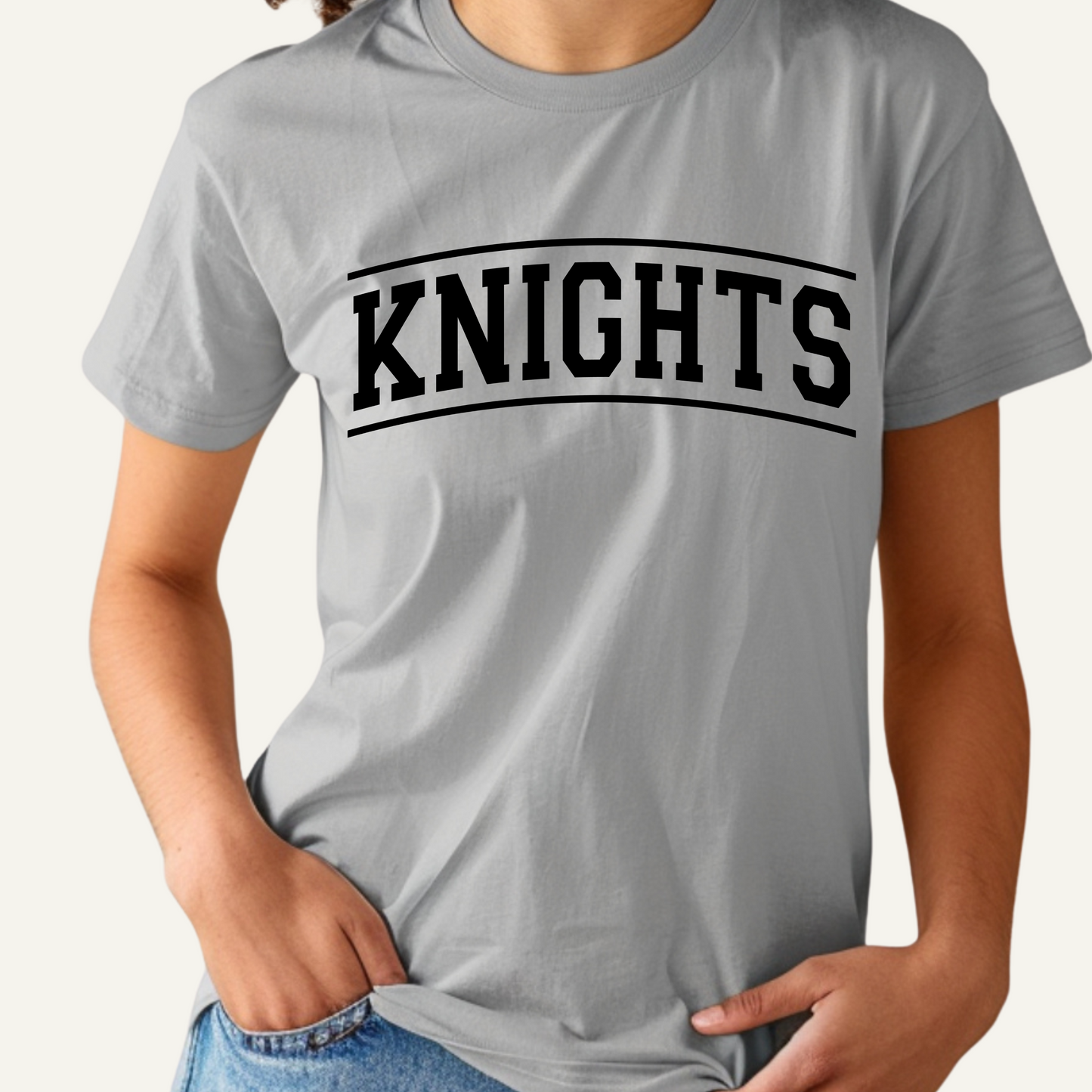 Gray t-shirt with 'KNIGHTS' printed on it worn by a person. Knights School Spirit Shirt - Knights Fan Merch - School Pride Graphic T-Shirt