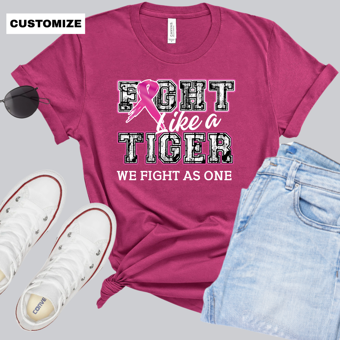 Pink t-shirt with 'Fight Like a Tiger' design, sunglasses, white sneakers, and jeans on a gray background. Custom Mascot T-Shirt: Fight Like a "Mascot" - Game Day Breast Cancer Support Tee