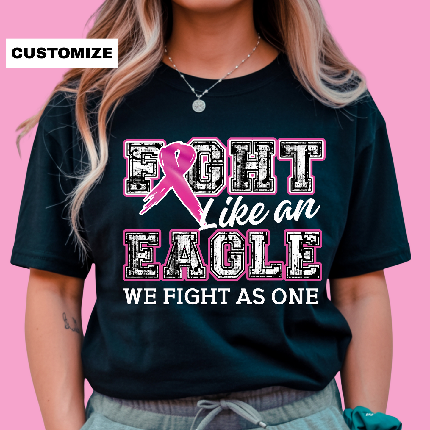 Person wearing a black t-shirt with a pink ribbon design and text on a pink background Custom Mascot T-Shirt: Fight Like a "Mascot" - Game Day Breast Cancer Support Tee