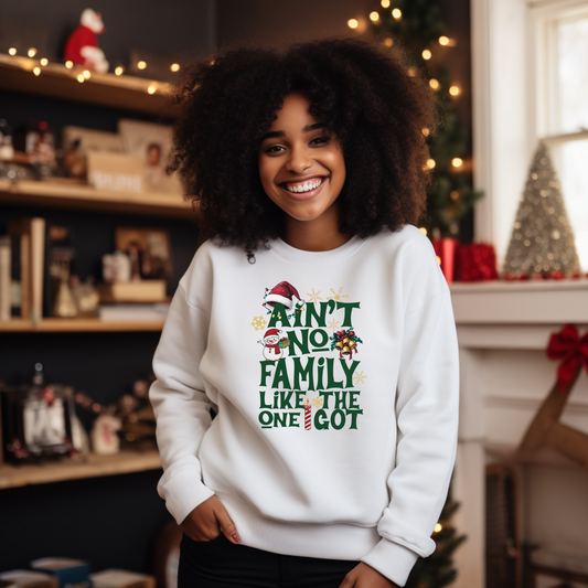 Person wearing a white sweatshirt with Christmas-themed text in a festive indoor setting.