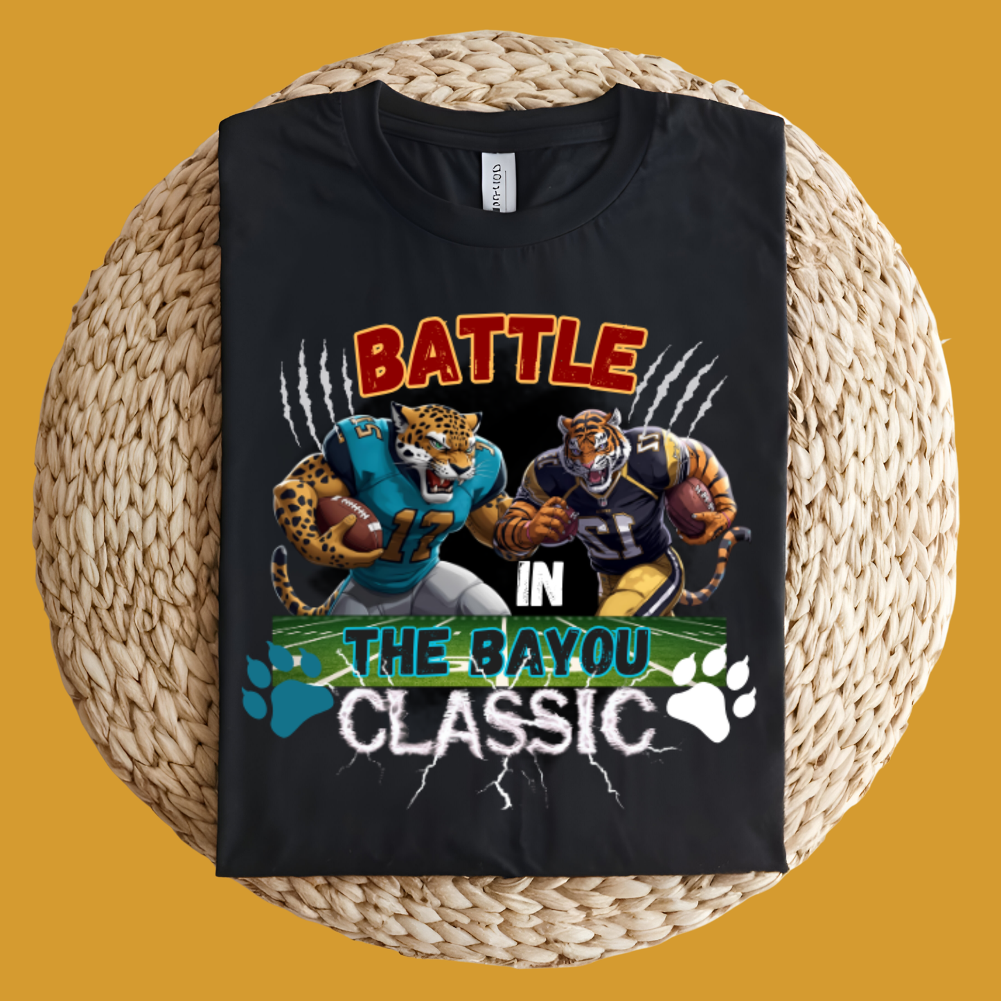 Black t-shirt with sports-themed design featuring leopards and text on a woven surface. Bayou Classic: Battle in the Bayou Classic Game Day Unisex T-Shirt