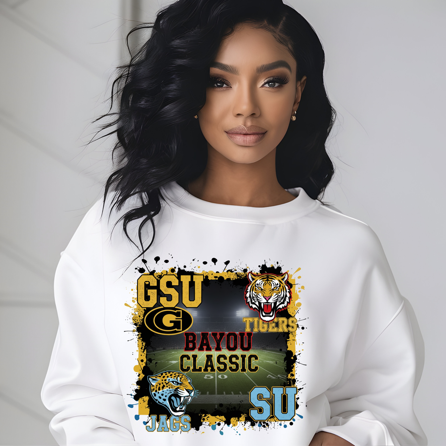 Woman wearing a white sweatshirt with a sports-themed design featuring 'GSU Tigers' and 'Bayou Classic'. Bayou Classic Football Sweater - Grambling State GSU Tigers vs. Southern University SU Jags Sweater