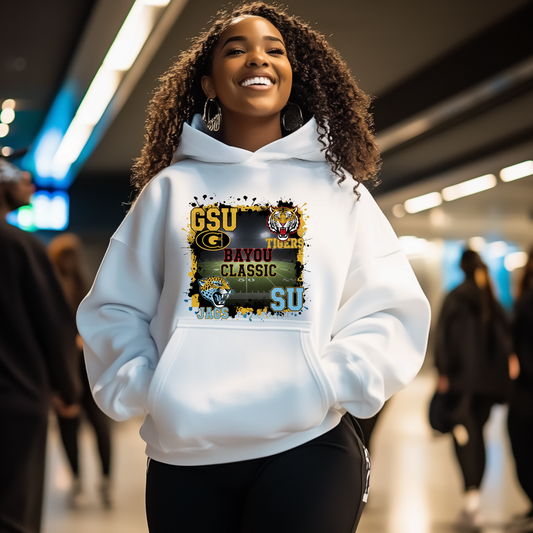 Person wearing a white hoodie with a graphic design in an indoor setting Bayou Classic Football Hoodie - Grambling State GSU Tigers vs. Southern University SU Jags Hoodie