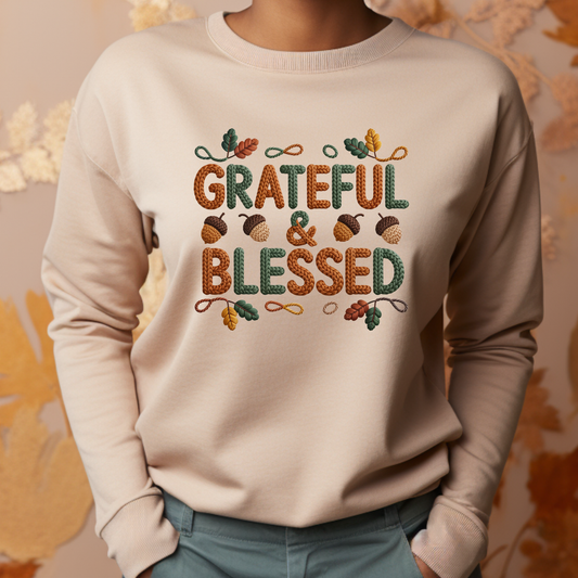 Beige sweatshirt with 'Grateful & Blessed' text and autumn-themed design on a neutral background