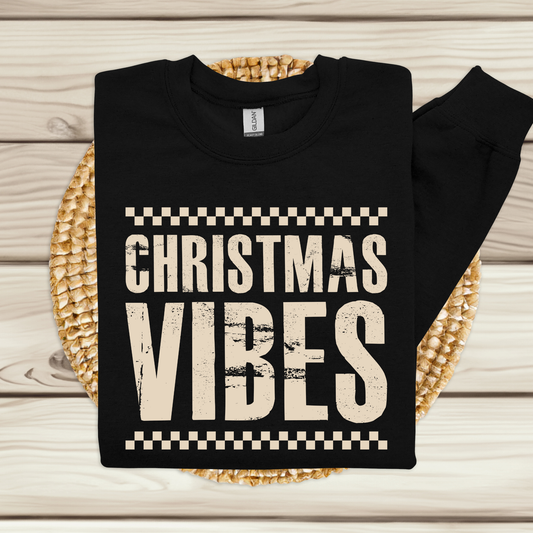 Black sweatshirt with 'Christmas Vibes' text on a woven mat