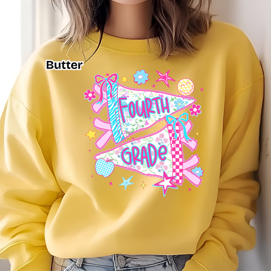 A person wearing a yellow sweatshirt with a colorful 'FOURTH GRADE' pennant graphic on the chest, paired with blue jeans. The word 'Butter' is printed on the upper left chest area.