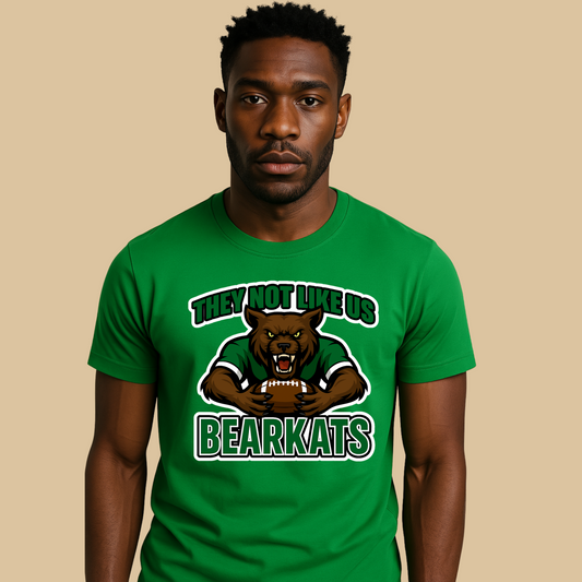 Man wearing a green t-shirt with a bear graphic and text on a beige background Custom Mascot Shirt - BearKats They Not Like Us Game Day Spirit Tee