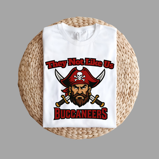 White t-shirt with pirate graphic and text on a woven mat Custom Mascot Shirt - Buccaneers They Not Like Us Game Day Wear