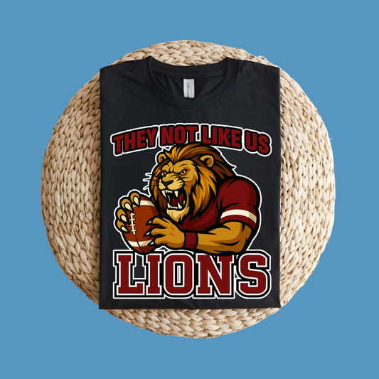 Black t-shirt with lion graphic and text on a woven surface Custom Mascot Shirt - Lions They Not Like Us Version 2 School Spirit Tee
