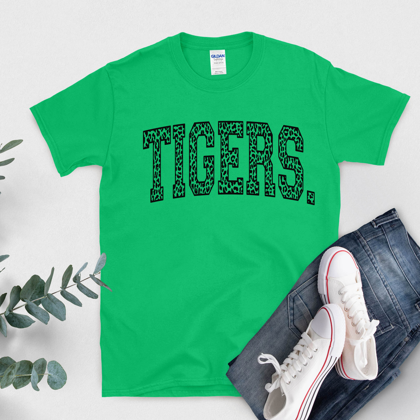 Green t-shirt with 'TIGERS' print, white sneakers, and jeans on a light gray background Custom Mascot Shirt - Tigers Leopard Varsity Typography Game Day T-Shirt