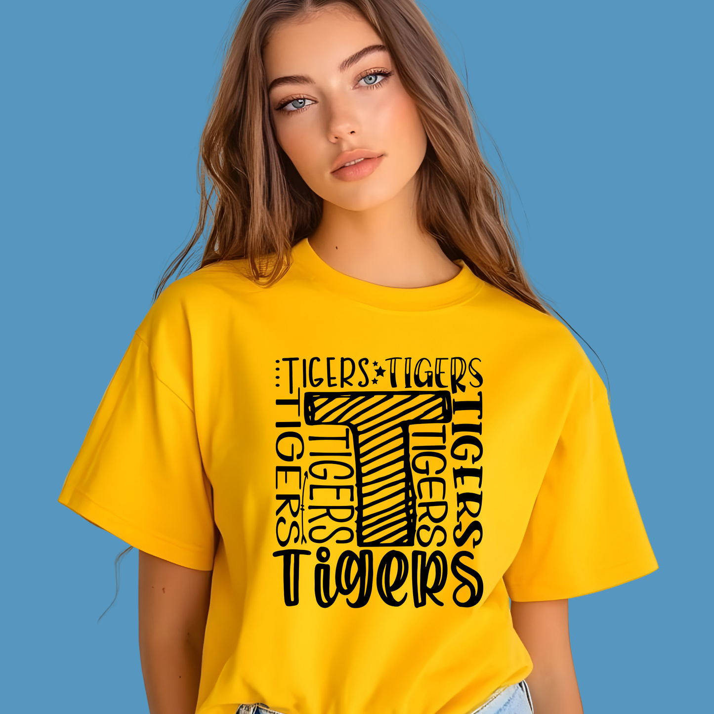 Woman wearing a yellow t-shirt with 'Tigers' text design on a blue background Custom Mascot Shirt - Tigers Pride Game Day Spirit Wear