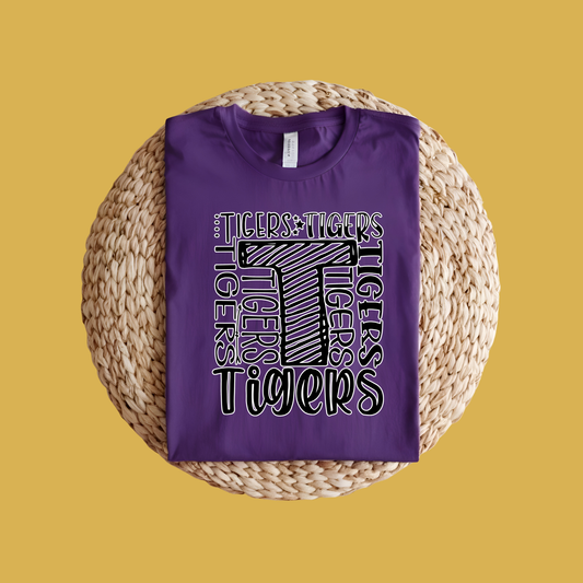 Purple t-shirt with 'Tigers' text design on a woven mat with a yellow background, Custom Mascot Shirt - Tigers Pride Game Day Spirit Wear