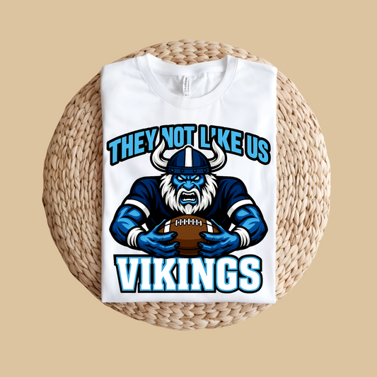 White tank top with Viking graphic and text on a woven surface Custom Mascot Shirt - Vikings They Not Like Us Game Day Wear