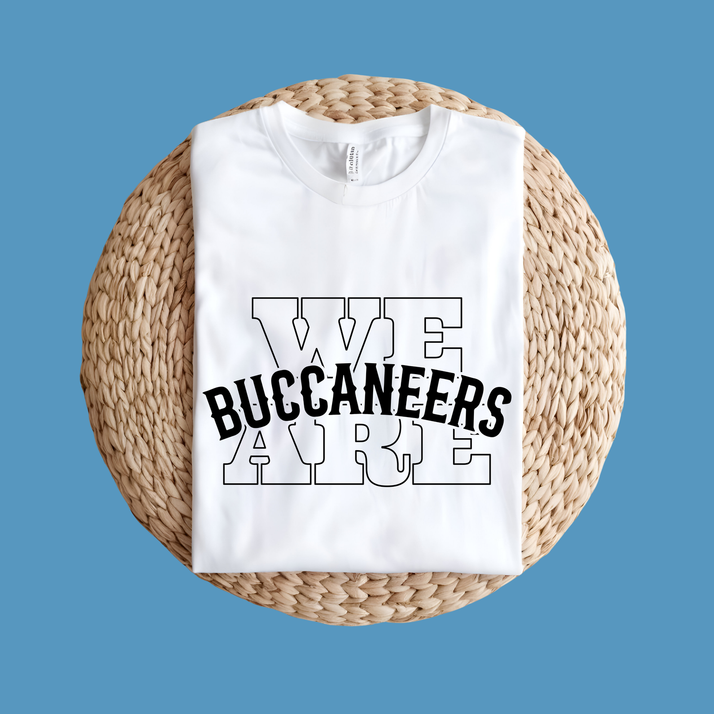 White t-shirt with 'WE BUCANEERS ARE' text on a woven mat against a blue background Custom Mascot Shirt - We Are Buccaneers School Spirit Tee