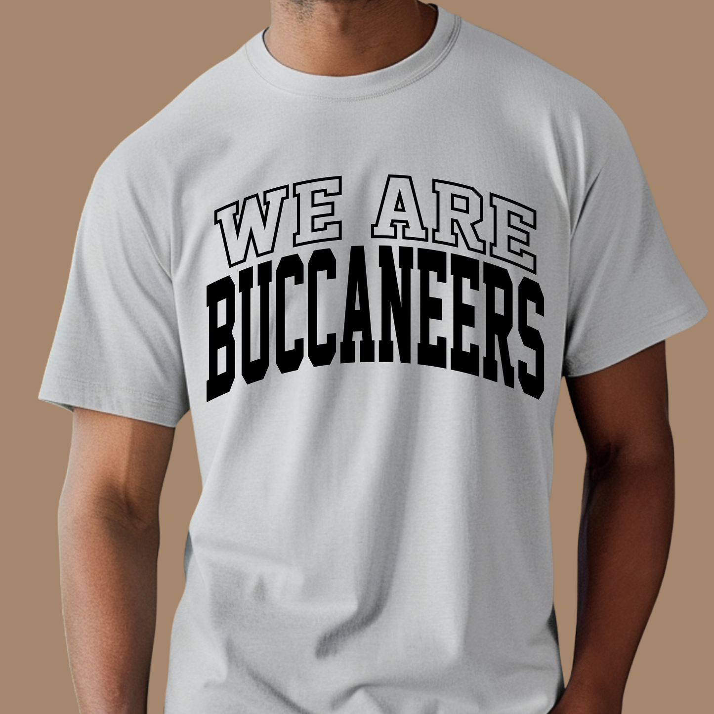 Person wearing a gray t-shirt with 'WE ARE BUCANEERS' text on a brown background Custom Mascot Shirt - We Are Tigers Game Day Spirit Wear