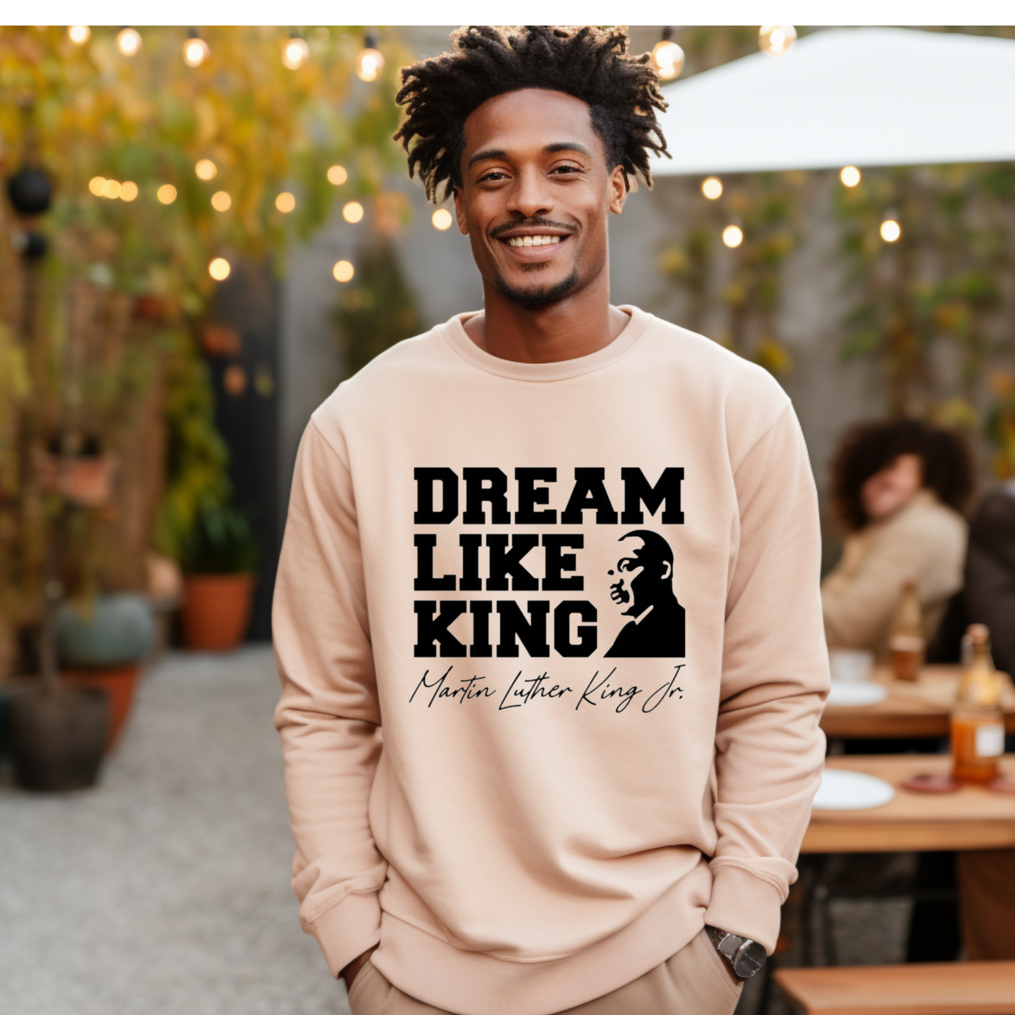 Black women wearing a black sweatshirt with the phrase "DREAM LIKE KING" and an image of Martin Luther King Jr., celebrating Black heritage and empowerment for MLK Birthday Celebration and holiday