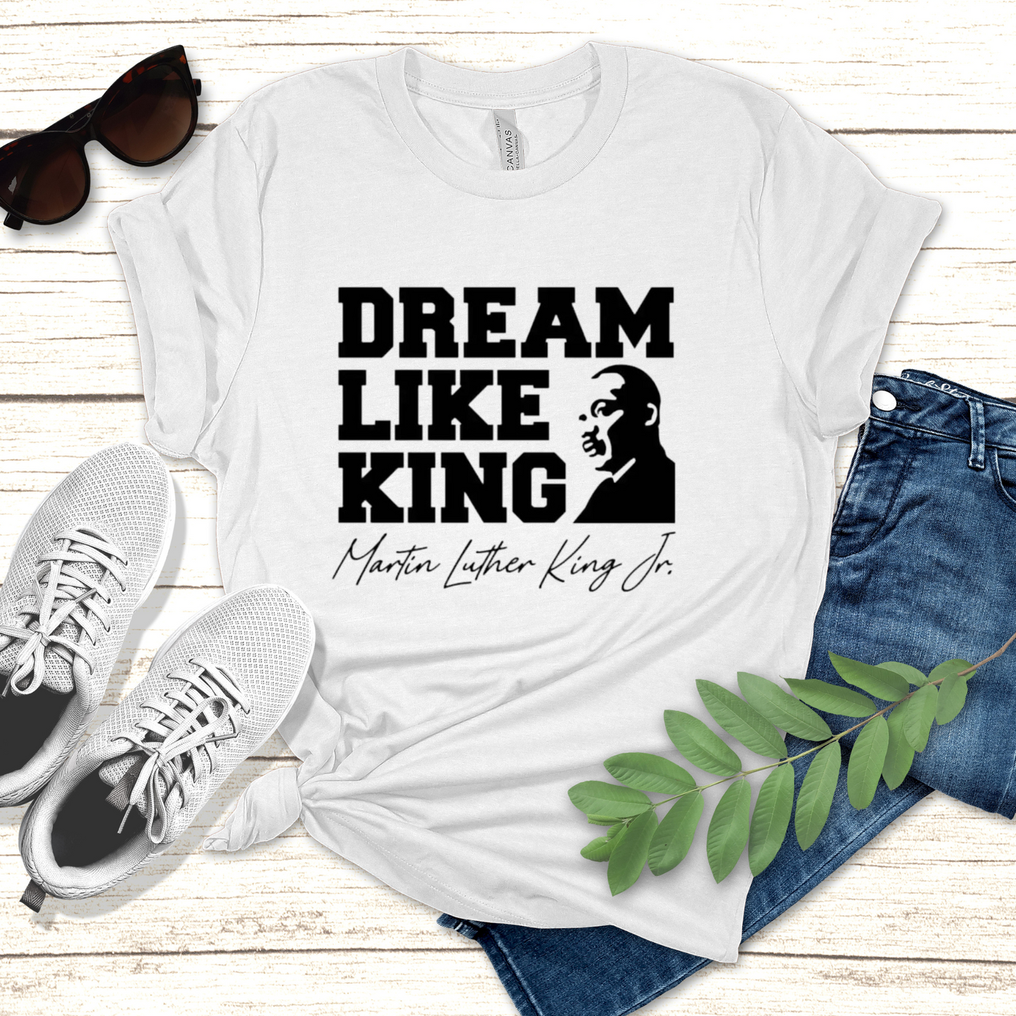 black men wearing a white shirt with the phrase "DREAM LIKE KING" and an image of Martin Luther King Jr., celebrating Black heritage and MLK Birthday with a t-shirt