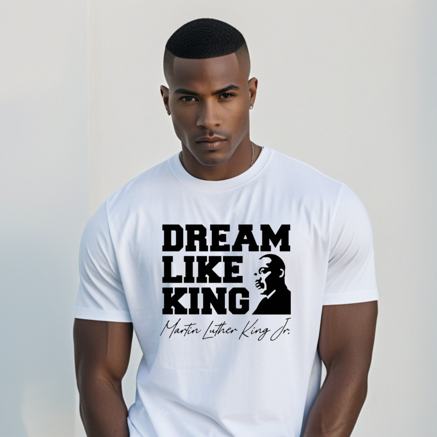 black men wearing a white shirt with the phrase "DREAM LIKE KING" and an image of Martin Luther King Jr., celebrating Black heritage and MLK Birthday with a t-shirt