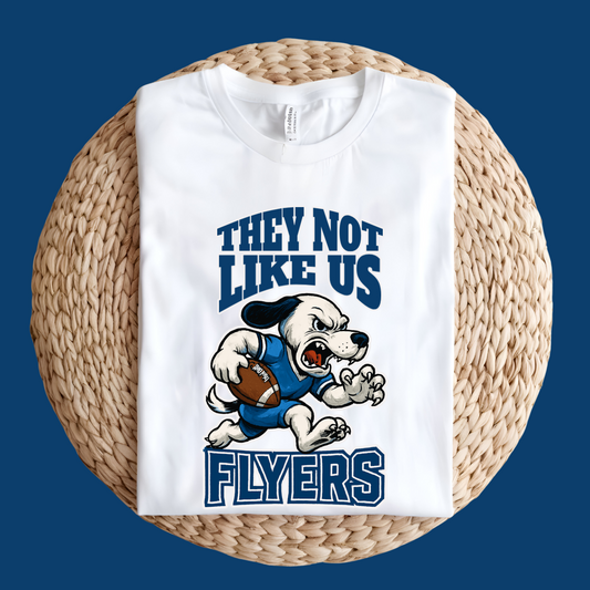 White sweatshirt with a graphic of a dog holding a football and text on a woven surface Flyers Mascot T-Shirt: "They Not Like Us" Flyers Game Day Graphic Tee