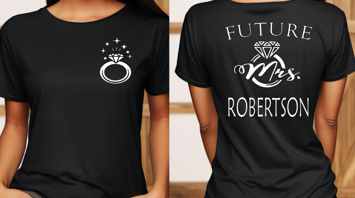 Woman wearing black shirt with FUTURE Mrs. on the back with bling ring on the front indicating engagement announcement shirt for bridal shower or engagement party and gift for new bride to be.