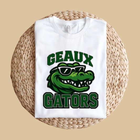 White sweatshirt with green alligator graphic and 'GEAUX GATORS' text on a woven surface. Gators Mascot Shirt - Geaux Gators Team Pride Shirt