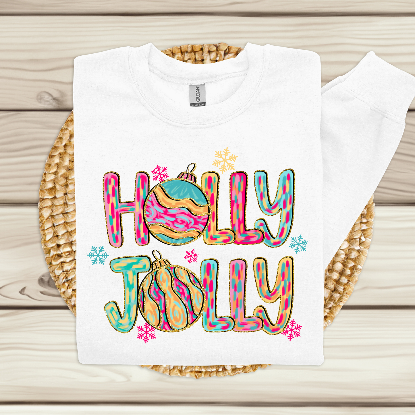 White t-shirt with 'Holly Jolly' design on a woven mat