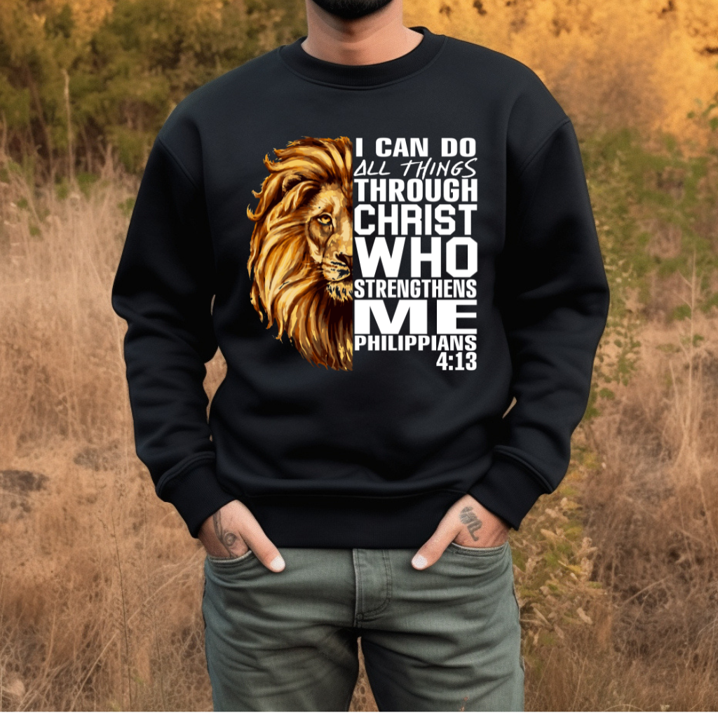 Lion Christian Sweatshirt "I Can Do All Things Through Christ" Unisex Man wearing a black Christian faith sweater with "I can do all things through Christ who strengthens me" and Lion of Judah design. Inspirational Christian sweatshirt