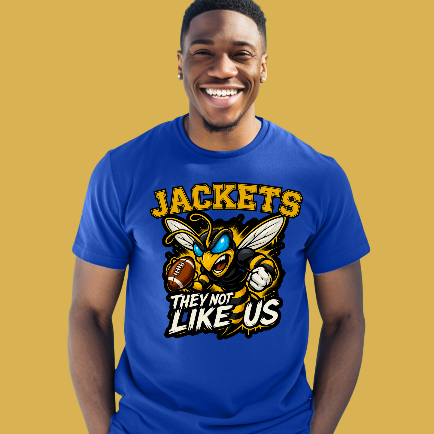 Man wearing a blue t-shirt with a 'JACKETS' graphic design on a yellow background Jackets Mascot Shirt - Bold Yellow Jacket They Not Like Us Game Day Tee