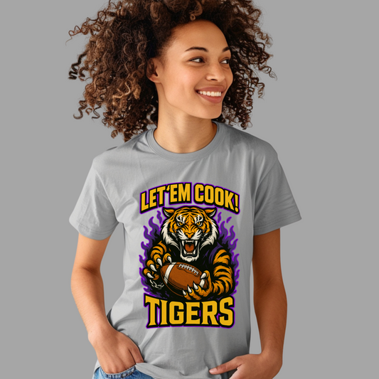 Person wearing a gray t-shirt with a tiger graphic and text on a gray background Let'em Cook Tigers Bold Graphic T-Shirt - Let'Em Cook Tigers Football Tee
