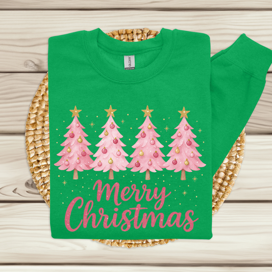 Green t-shirt with pink Christmas trees and 'Merry Christmas' text on a woven mat.