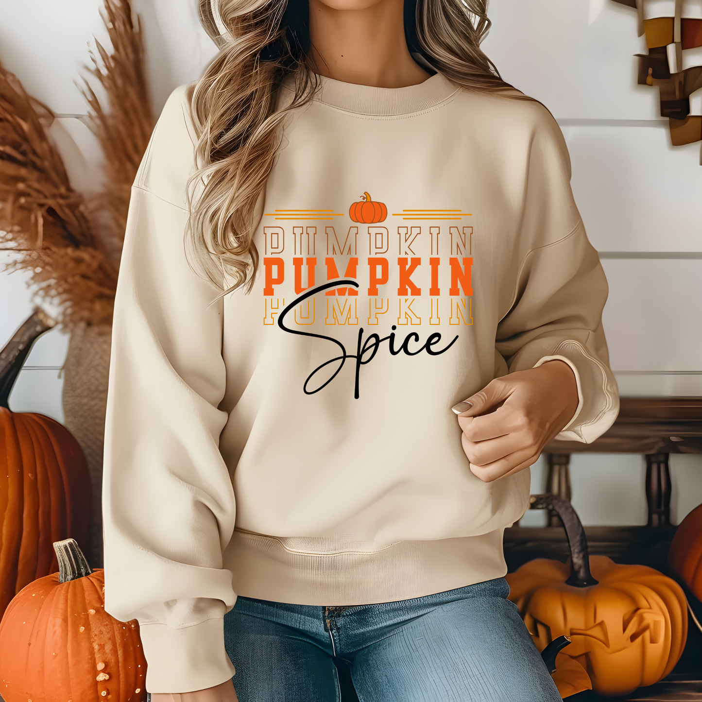 Person wearing a beige sweatshirt with 'Pumpkin Spice' text in an autumn-themed setting