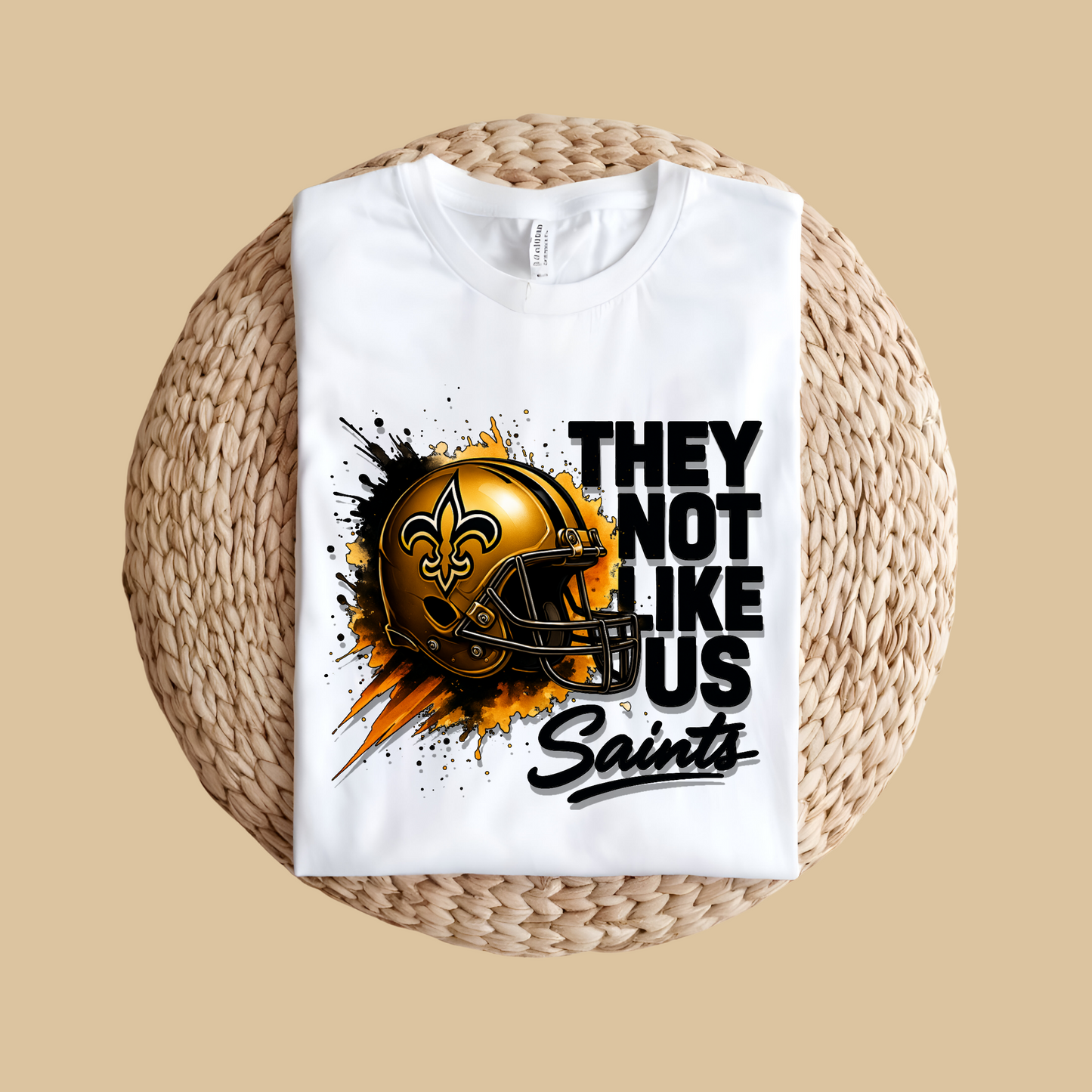 White t-shirt with a football helmet graphic and text on a woven surface Saints Mascot Shirt - Ultimate Saints Fan They Not Like Us Tee