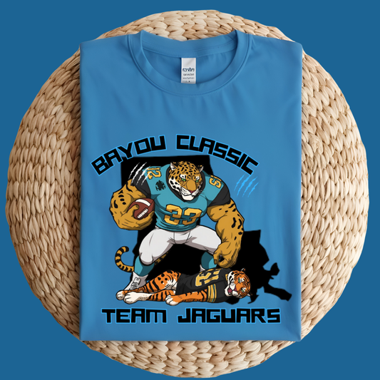 Blue t-shirt with 'Bayou Classic Team Jaguars' design featuring a tiger and football player on a woven surface. Bayou Classic Team Jaguars: Bayou Classic Team Jaguars Game Day T-Shirt