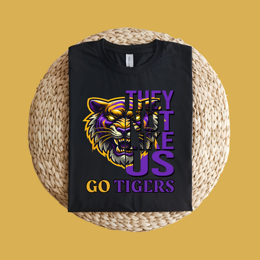 Black t-shirt with a tiger graphic and text on a woven surface Tigers Mascot Shirt - Bold Tigers They Not Like Us Team Pride Tee