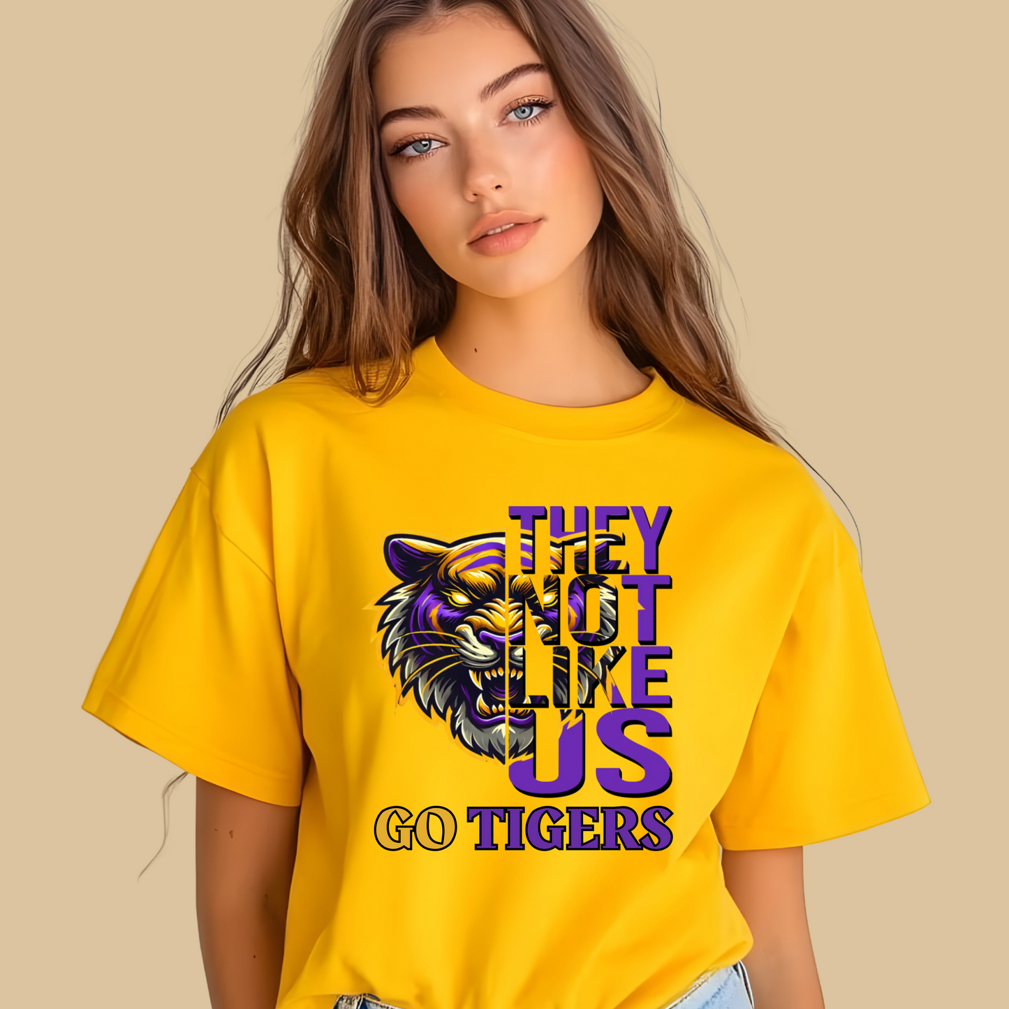Woman wearing a yellow t-shirt with a tiger graphic and text on a beige background Tigers Mascot Shirt - Bold Tigers They Not Like Us Team Pride Tee