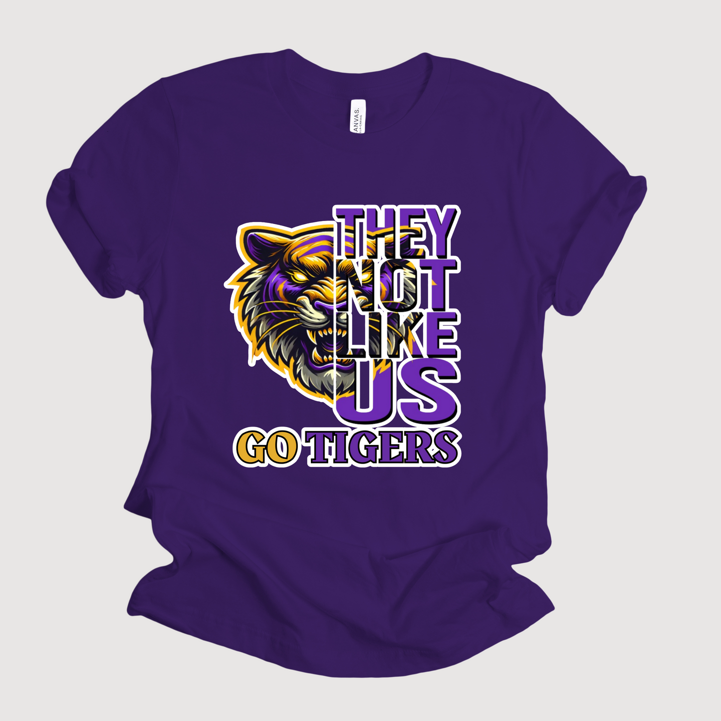 Purple t-shirt with tiger graphic and text on a white background Tigers Mascot Shirt - Bold Tigers They Not Like Us Team Pride Tee