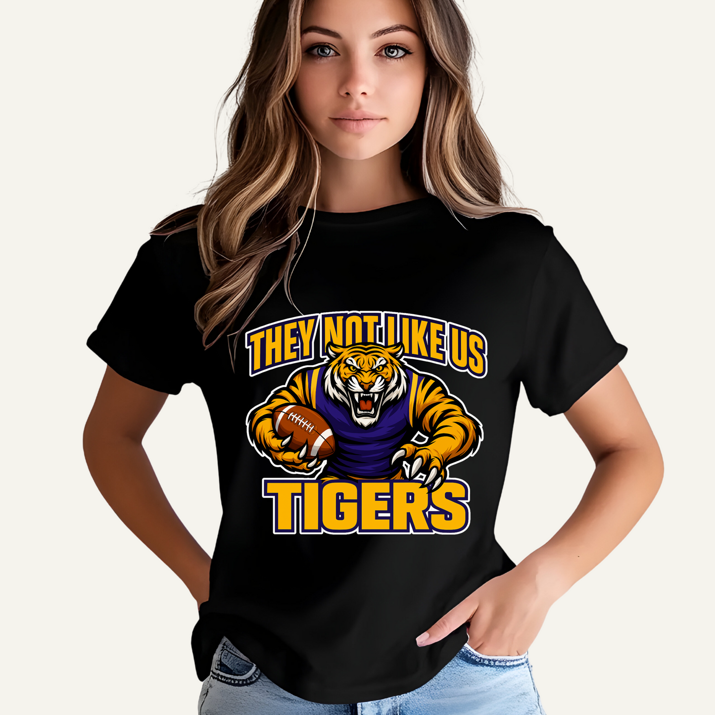 Person wearing a black t-shirt with a tiger graphic and text on a plain Tigers Mascot T-shirt - Tigers They Not Like Us Game Day Spirit Tee Louisiana Tigers Football T-shirt - Tigers "They Not Like Us" Game Day Spirit Tee
