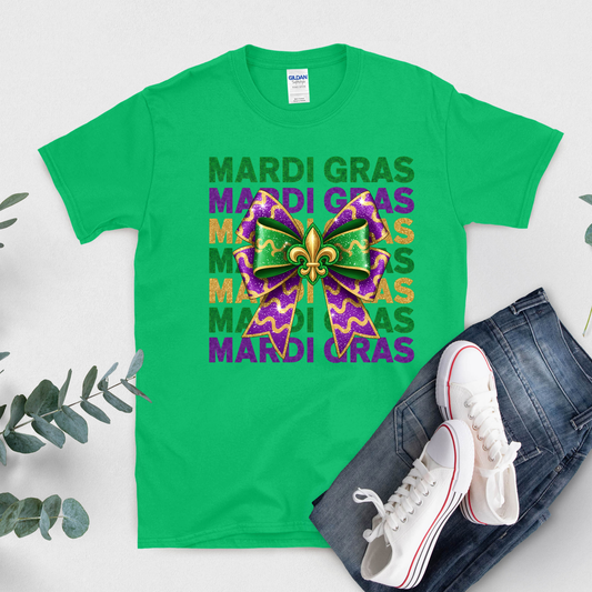 Green t-shirt with Mardi Gras design, white sneakers, and jeans on a light gray background