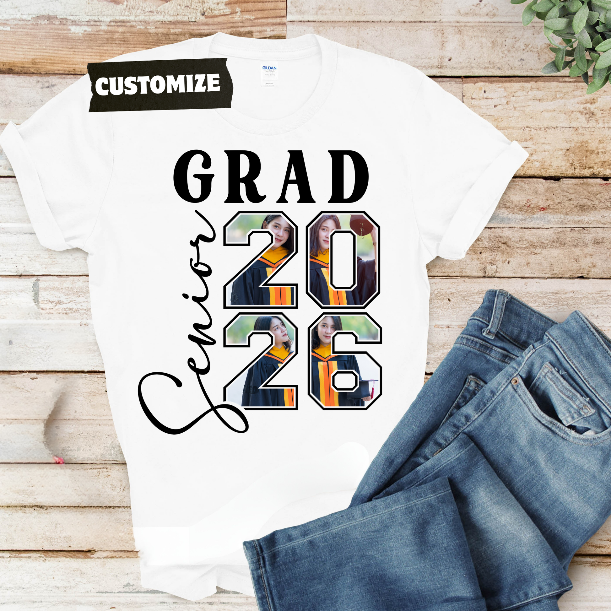 Graduation-themed t-shirt with 'GRAD 2026' design on a wooden surface with jeans.