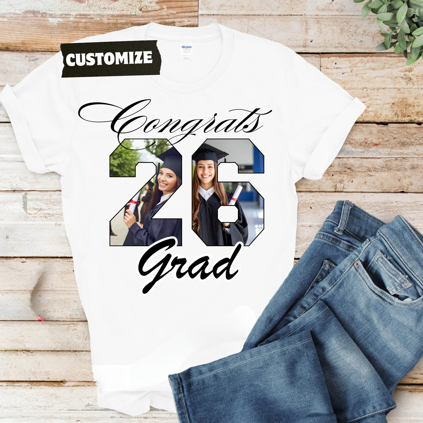 Graduation-themed t-shirt with customizable design on a wooden surface with jeans.  Customizable graduation photo t-shirt featuring senior portrait, school mascot, and sports organization logos in school colors