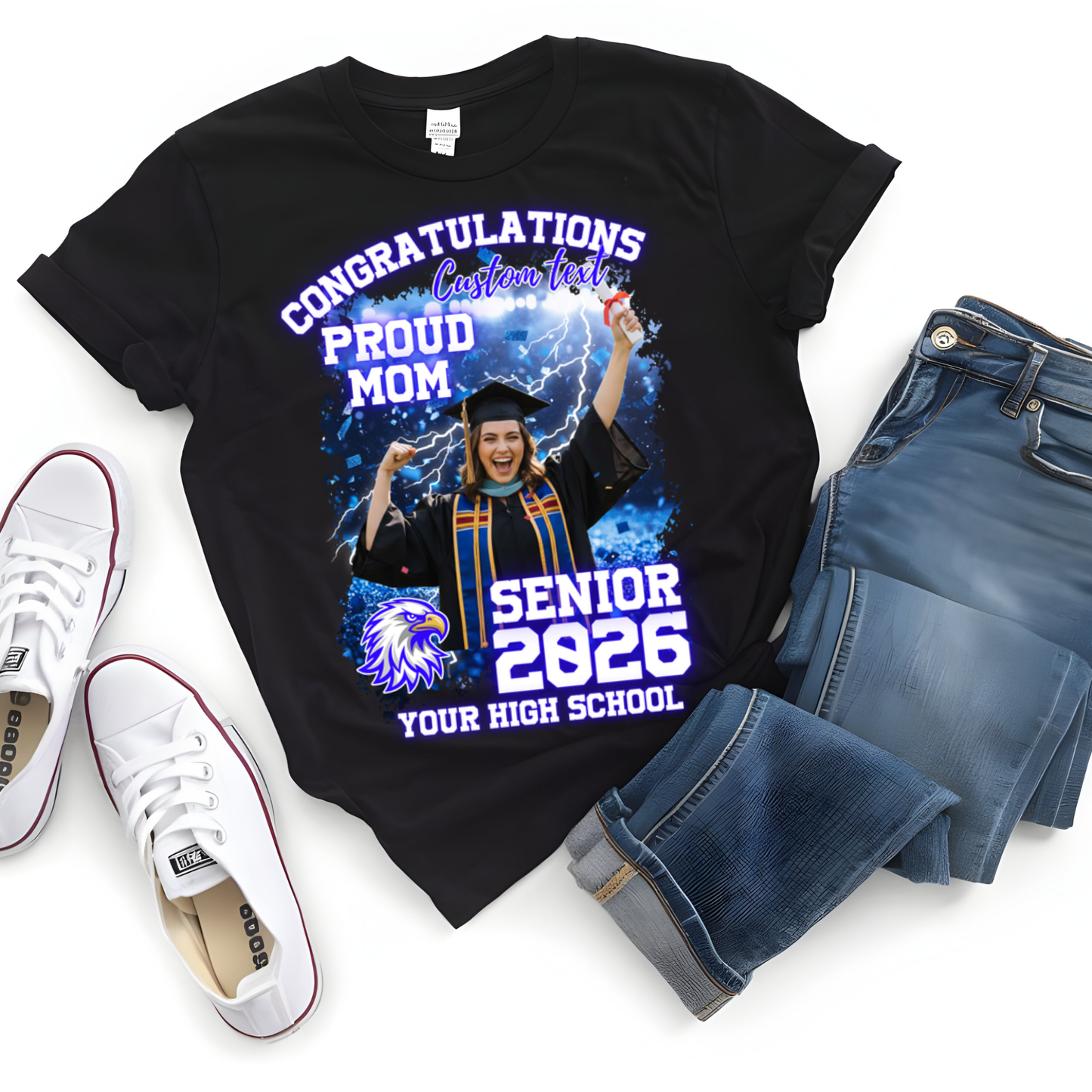 Black t-shirt with graduation design, jeans, and white sneakers on a white background  Customizable graduation photo t-shirt featuring senior portrait, school mascot, and sports organization logos in school colors