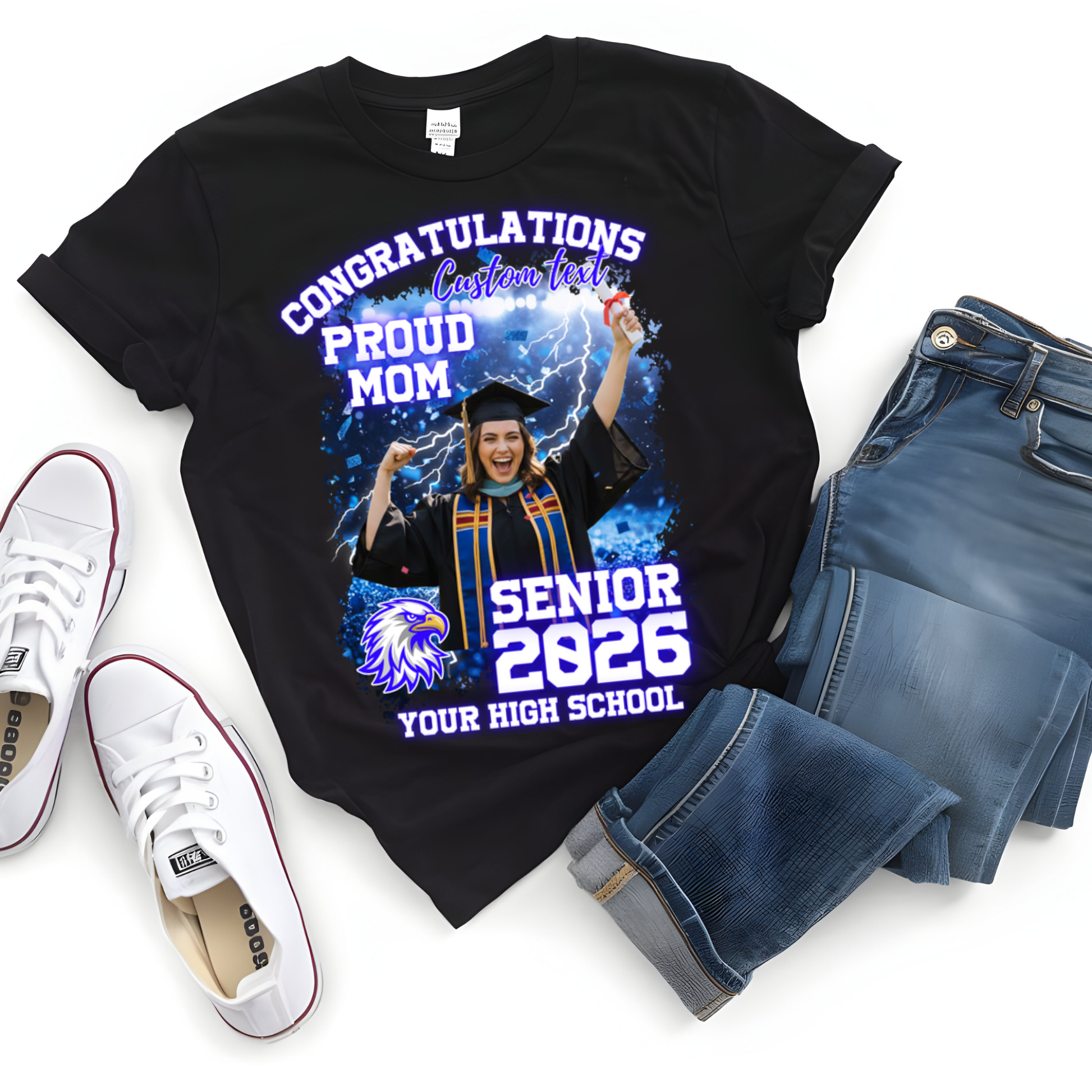 Black t-shirt with graduation design, jeans, and white sneakers on a white background  Customizable graduation photo t-shirt featuring senior portrait, school mascot, and sports organization logos in school colors