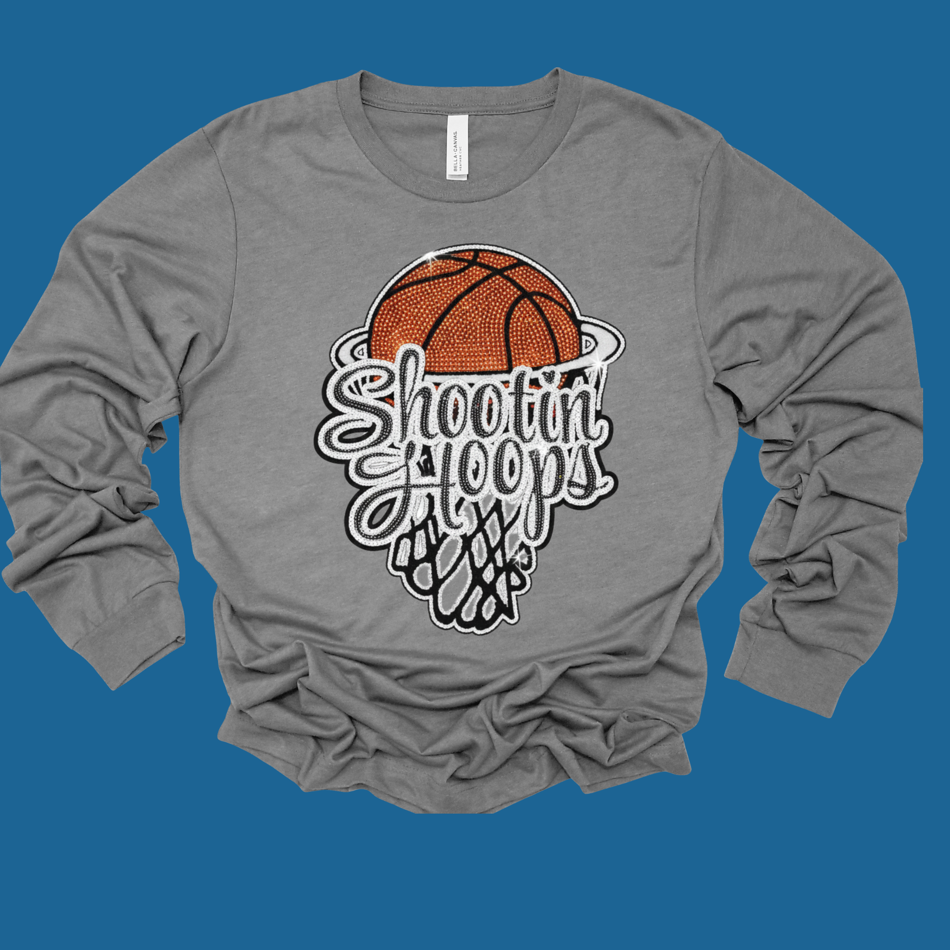 Gray long-sleeve shirt with a basketball graphic and 'Shooting Hoops' text on a blue background