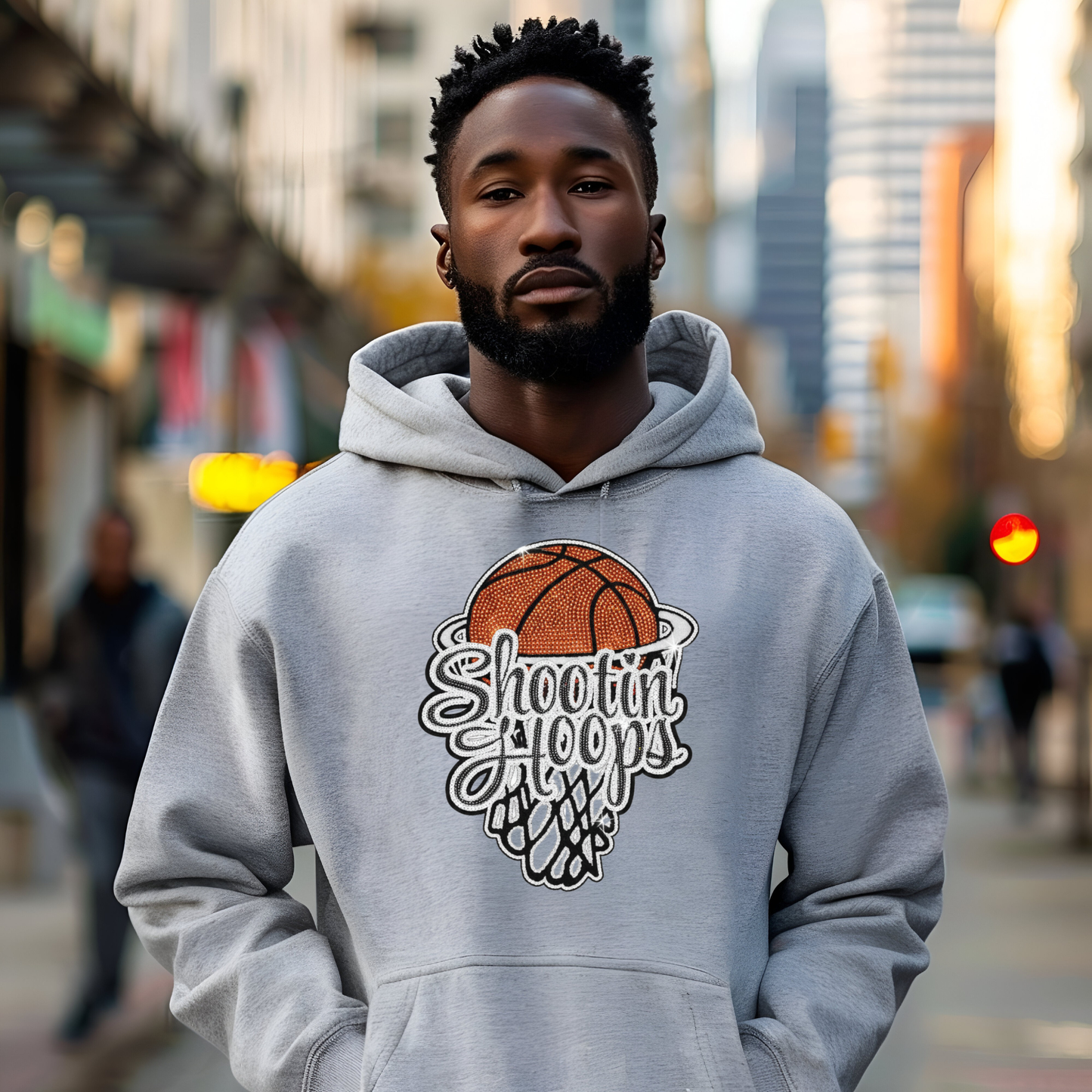 Man wearing a gray hoodie with a basketball design and text in an urban setting