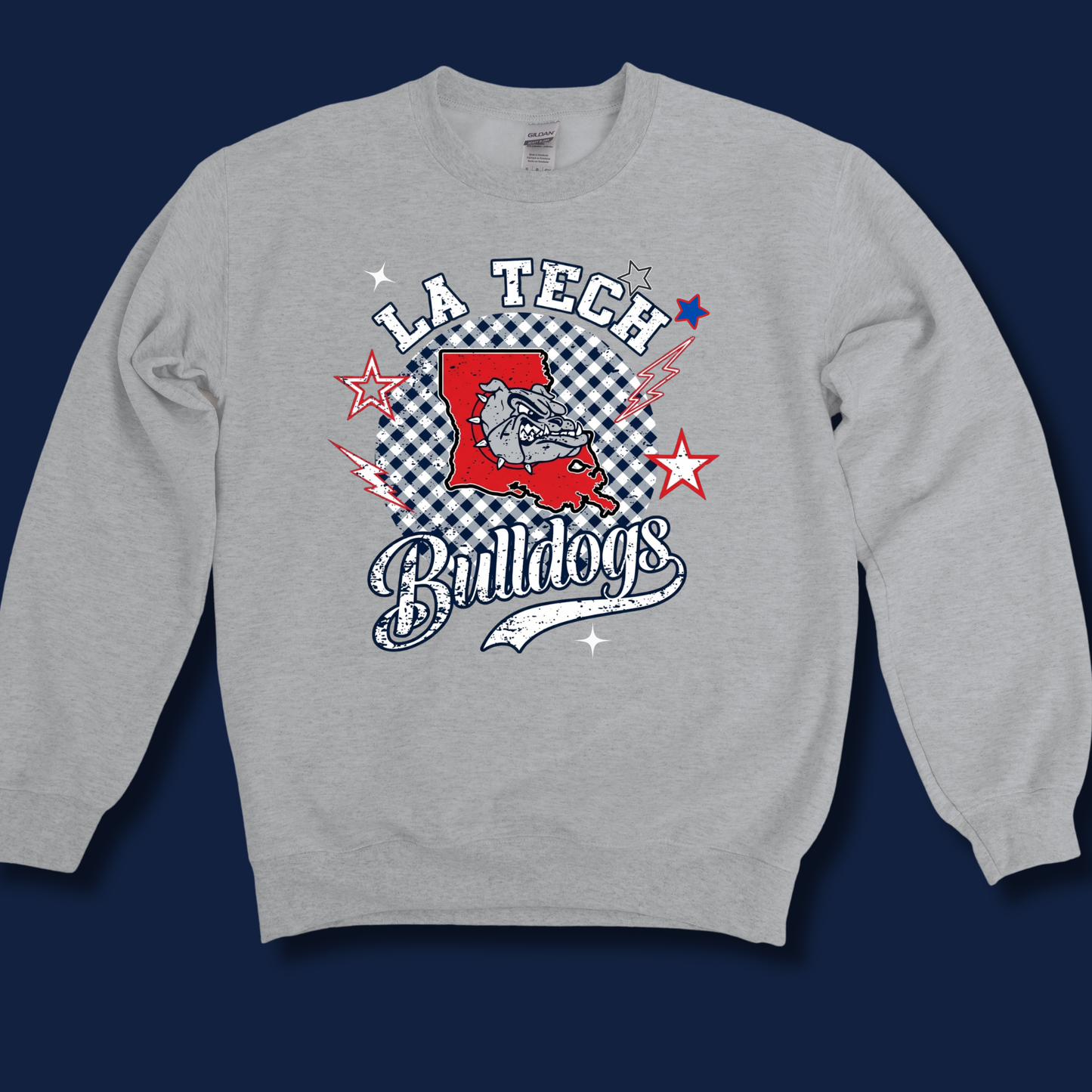 A light heather gray crewneck sweatshirt featuring a 'LA Tech Bulldogs' graphic on the chest, displayed against a solid dark navy blue background.