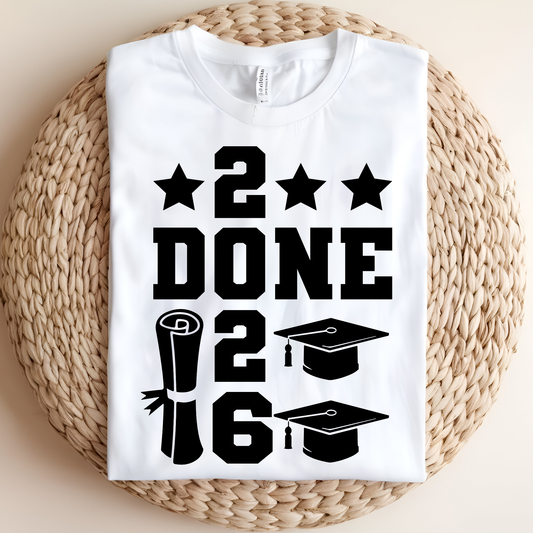 White t-shirt with black graduation-themed design on a woven mat