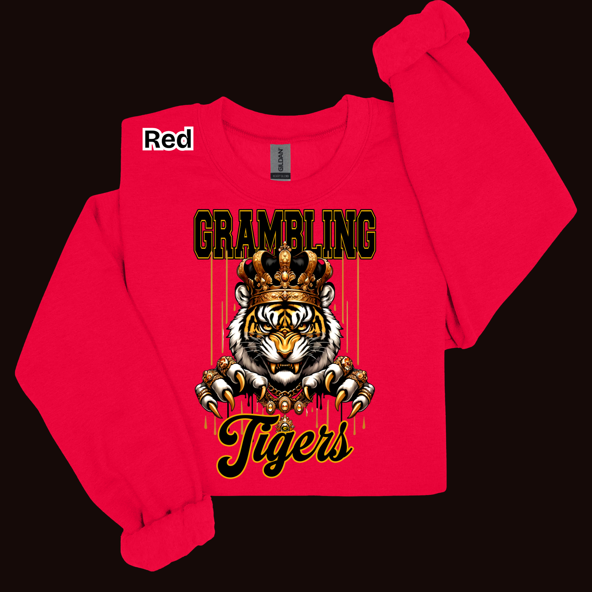 A bright red long-sleeve sweatshirt laid flat on a black background, featuring a large graphic print of a tiger wearing a gold crown with the words 'GRAMBLING Tigers' in black and gold. A small white label near the collar reads 'Red'.